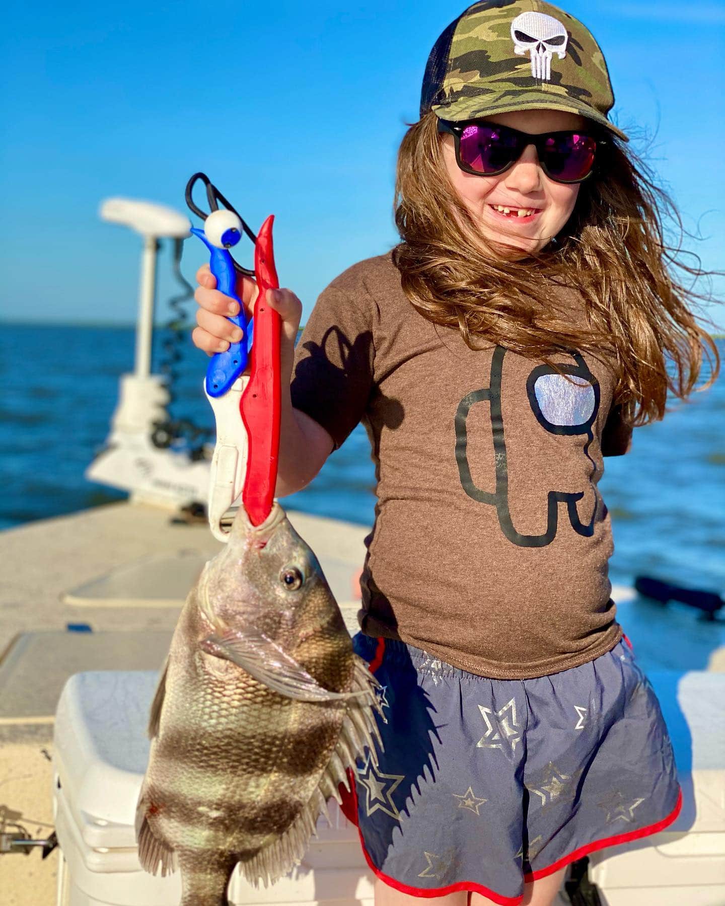 Girl holding up a sheepshead she caught while on a fishing charter in Delacroix.