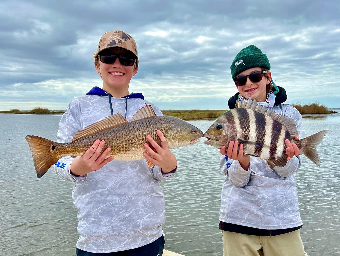 Two boys holding up the fish they caught while on a fishing charter in Delacroix, LA.