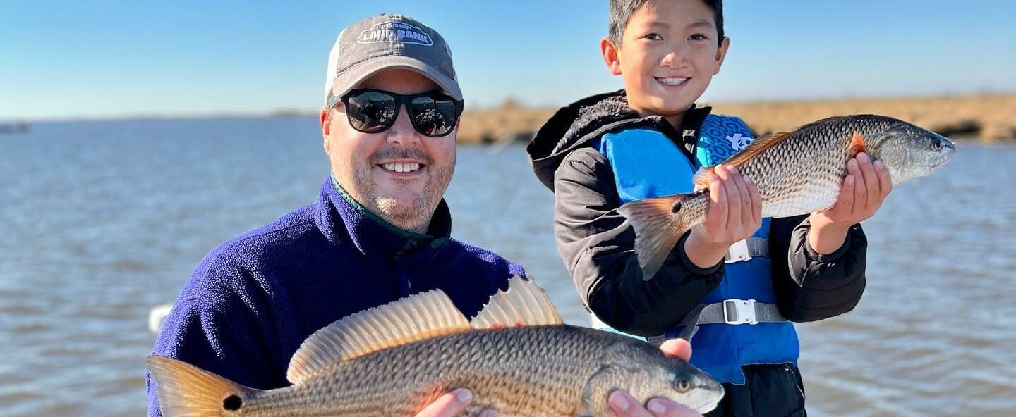 Father and son holding up the fish they caught in Delacroix, LA.