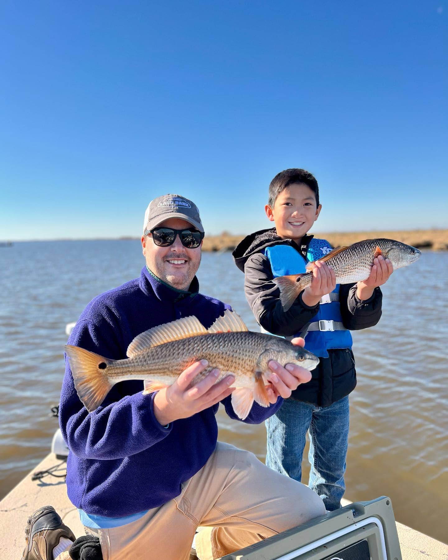 Father and son holding up the fish they caught in Delacroix, LA.