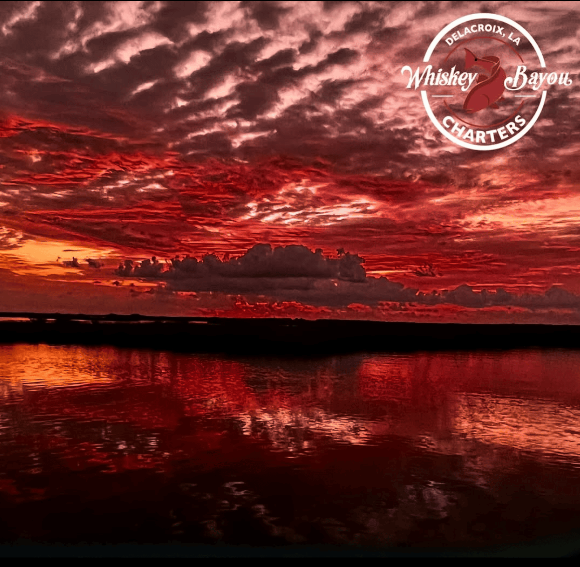 Moody red sky reflected by the waters of the marsh