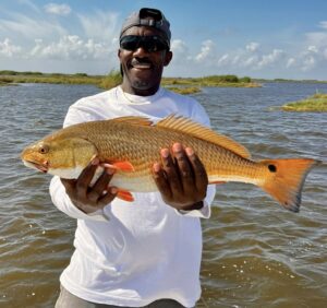 A happy angler holding up a redfish